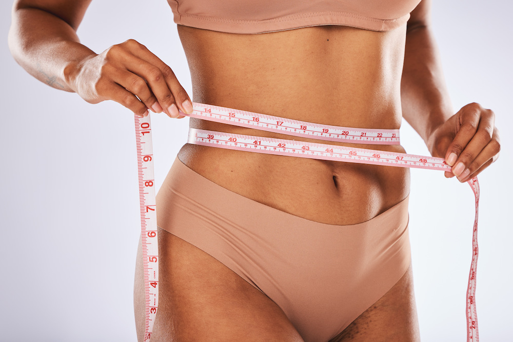 Woman Holding Tape Measure Around Her Stomach